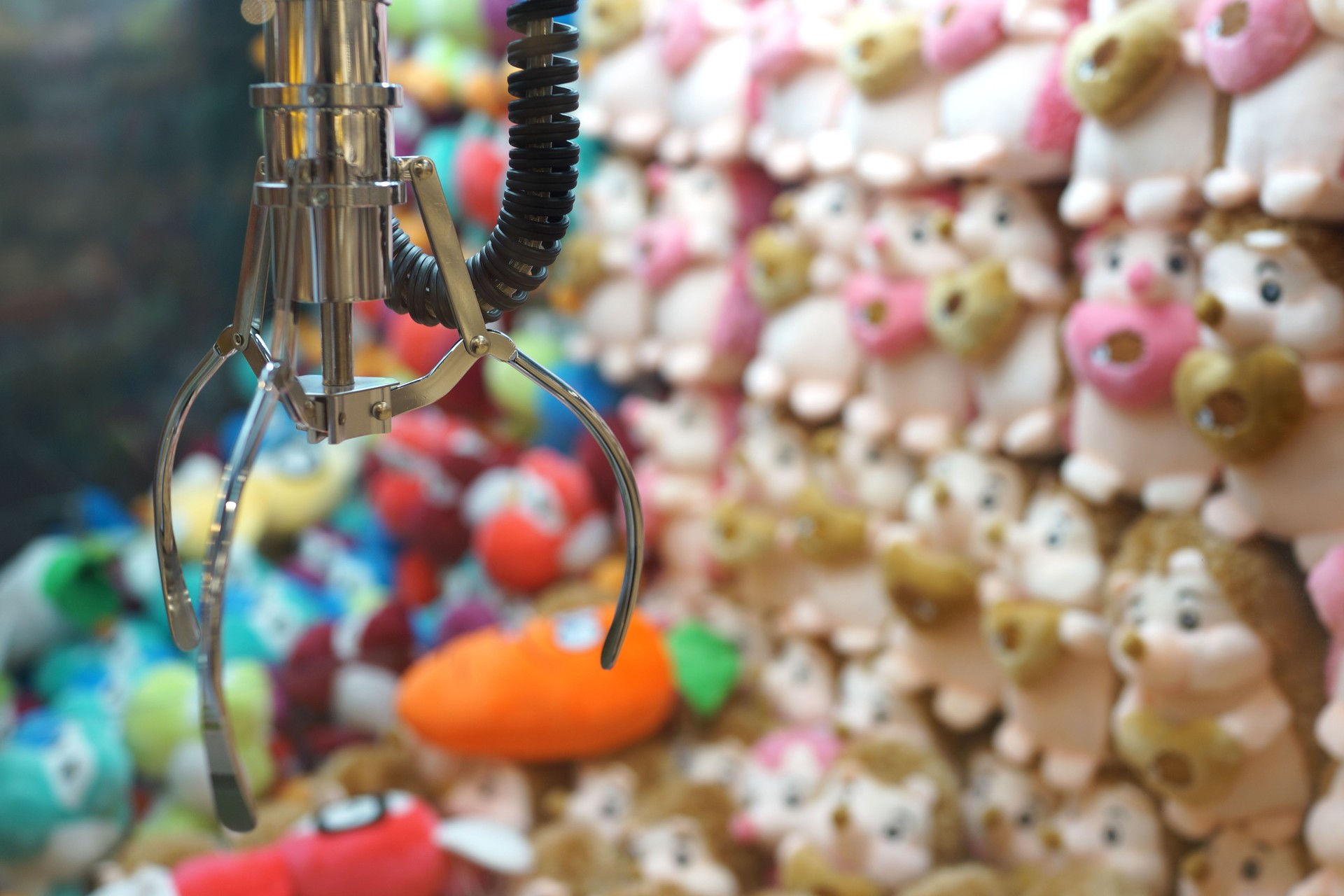 Close up of the doll claw machine of games arcade in shopping mall