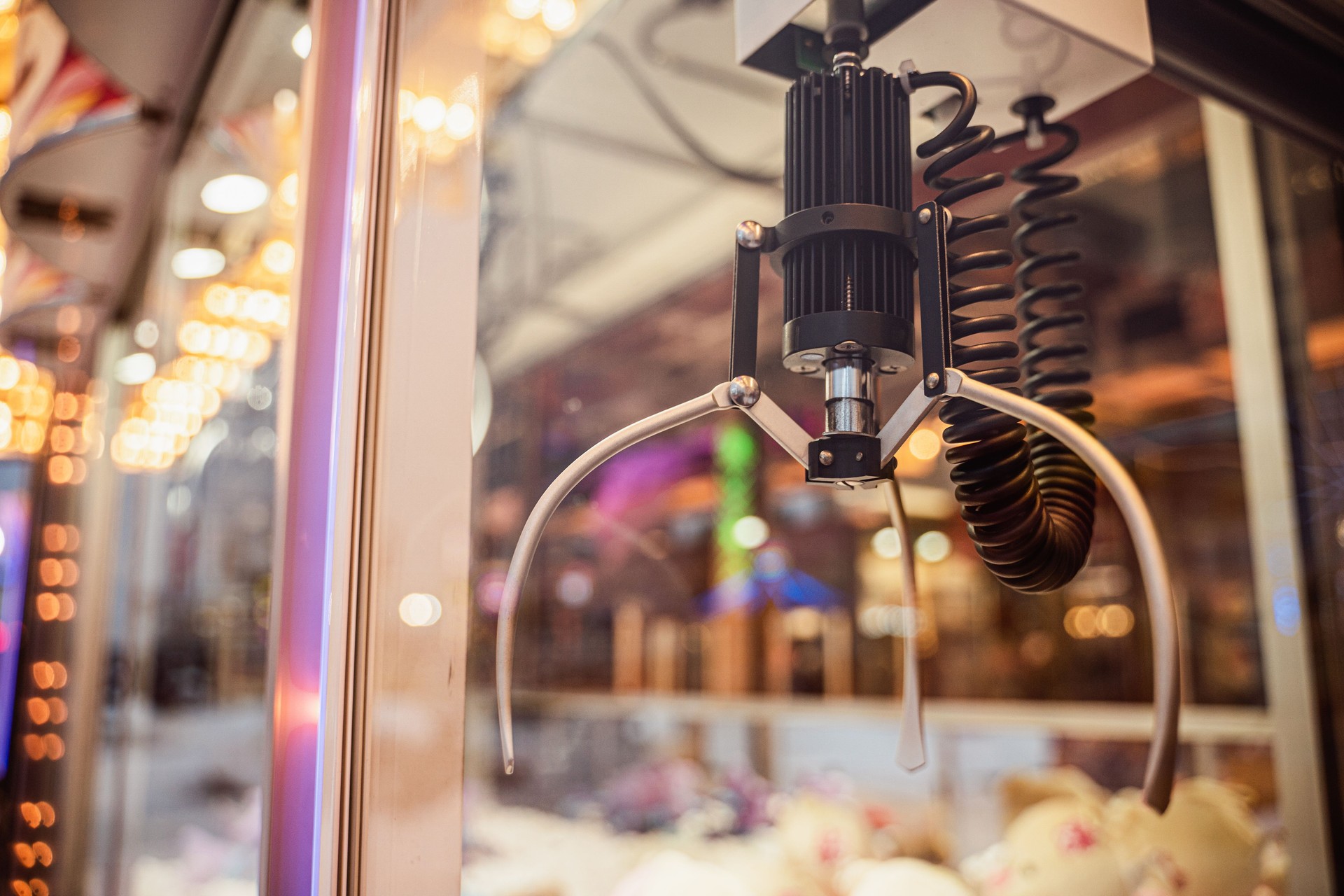 Close-up of the claw machine arcade game in an evening amusement park